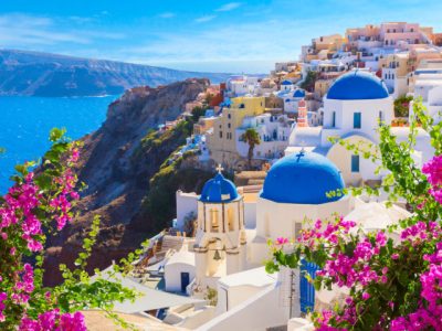 Santorini island, Greece. Oia town traditional white houses and churches with blue domes over the Caldera, Aegean sea.